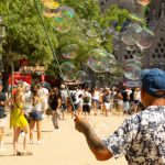 Street artist creates large bubbles amidst a crowd near Sagrada Familia.
